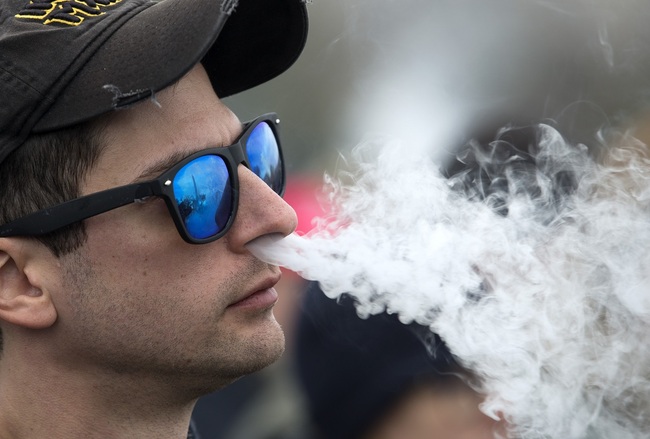 File Photo: A demonstrator vapes during a consumer advocate groups and vape storeowners rally outside of the White House to protest the proposed vaping flavor ban in Washington, DC, on November 9, 2019. [Photo: AFP/Jose Luis Magana]