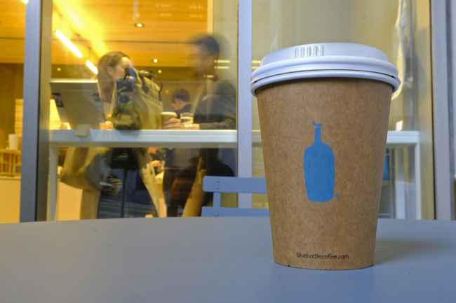 In this Thursday, Dec. 12, 2019 photo, a Blue Bottle Coffee paper to-go cup rests on a table outside one of their cafes in San Francisco. The Oakland-based chain says it's getting rid of disposable cups at two locations next year, as part of a pledge to go “zero-waste” at its 70 U.S. locations by the end of 2020. [Photo: AP]