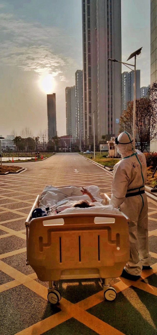 Doktor Liu Kai a 87letý pacient COVID-19 Wang Xin se zastavili a sledují večerní záři v nemocnici ve Wuhanu v centrální čínské provincii Hubei; 5. března 2020. / Gan Junchao