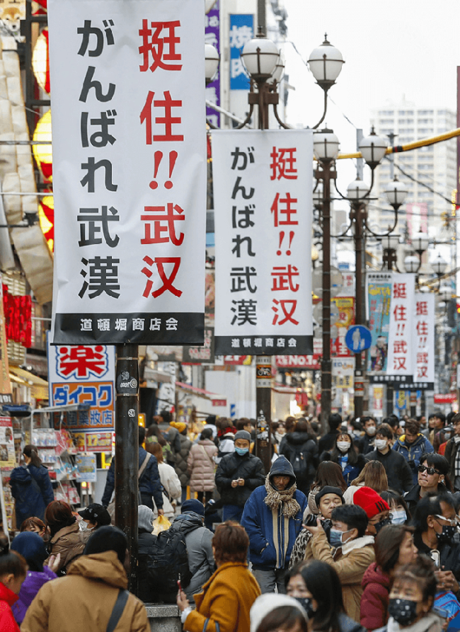 Snímek: Návěstní tabule s čínskými a japonskými slovy „ Zůstaň silný, Wuhane“ jsou v ulici v Dotonbori v Ósace v Japonsku, což ukazuje podporu Japonců pro Čínu v boji proti COVID-19; 1. února 2020. / Xinhua