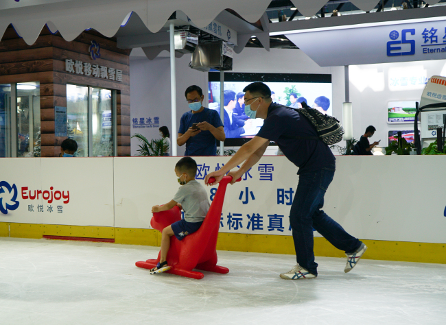 Návštěvníci zažívají zimní sport na ledu s dětmi. Fotografie: CMG