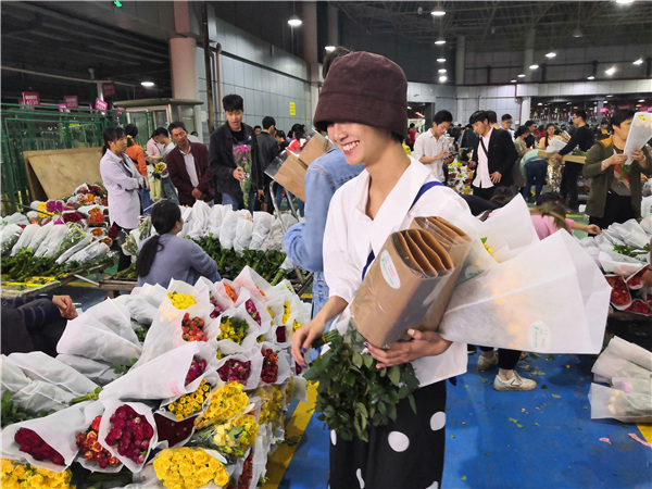 Na snímku zákaznice v srpnu kupuje květiny na květinovém trhu Dounan v Kunmingu v provincii Yunnan. Fotografie: Wang Ru / China Daily