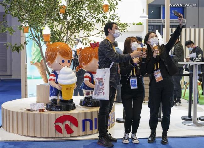 9, Lidé si dělají selfie na výstavišti potravin a zemědělských produktů během třetího Čínského mezinárodního dovozního veletrhu (CIIE) v Šanghaji ve východní Číně, 10. listopadu 2020. Expo podle plánu potrvá do 10. listopadu. Zaměstnanci, vystavovatelé a návštěvníci fotografují, aby si uchovali vzácné okamžiky akce. (Xinhua / Zhang Haofu)