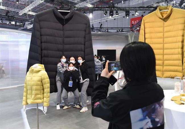 1, Návštěvníci pózují pro fotografii před stánkem značky neformálního oblečení Uniqlo během třetího Čínského mezinárodního dovozního veletrhu (CIIE) v Šanghaji ve východní Číně, 10. listopadu 2020. Expo podle plánu potrvá do 10. listopadu. Zaměstnanci vystavovatelé a návštěvníci fotografují, aby si uchovali vzácné okamžiky této akce. (Xinhua / Zhao Dingzhe)