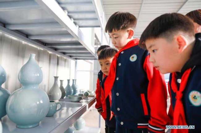 3, Žáci základních škol se 15. listopadu 2020 dívají na porcelánové práce v dílně porcelánu Ru (Žu) v okrese Baofeng (Pao-feng) v provincii Henan (Che-nan) ve střední Číně. Okres Baofeng je známý výrobou porcelánu Ru, jednoho z pěti známých porcelánů během dynastie Song (Sung, 960-1279) ve starověké Číně. Více než 90 studentů základní školy Xichengmen (Si-čcheng-men) v okrese Baofeng se zde v neděli zúčastnilo praktické aktivity, kde se dozvěděli o porcelánu Ru. (Foto He Wuchang / Xinhua)