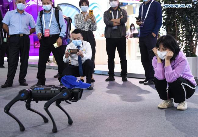 6, Návštěvníci se dívají na robotického psa na výstavě s tématem 5G, která se konala během Světové konference 5G v Kantonu v jihočínské provincii Guangdong (Kuang-tung), 26. listopadu 2020. Světová konference 5G v roce 2020 byla zahájena ve čtvrtek v Kantonu. Světoví renomovaní vědci z oblasti telekomunikace, poskytovatelé služeb 5G a uživatelé aplikací 5G si budou vyměňovat nápady týkající se aspektů špičkových technologií, trendů průmyslového rozvoje a inovativních aplikací v oblasti 5G. (Xinhua / Deng Hua)