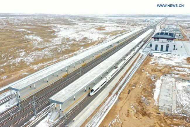 Letecký snímek pořízený 12. prosince 2020 zachycuje vlak stojící na nádraží Huianbu (Chuej-an-pu) během zkušebního provozu vysokorychlostní železnice Yinchuan (Jin-čchuan) - Xi'an (Si-an). Vysokorychlostní železnice Yinchuan-Xi'an má být uvedena do provozu (Xinhua / Feng Kaihua)