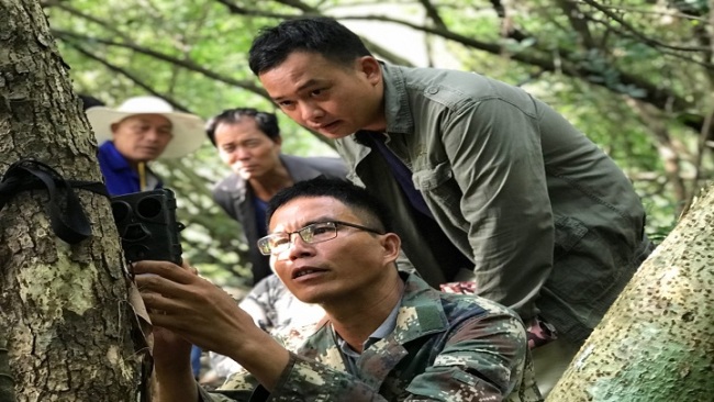Snímek 2: Členové týmu dobrovolné hlídky v Qunantun (Čchü-nan-tchun) si během hlídky prohlížejí záběry z infračervené kamery