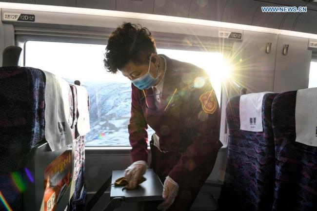 Zdravotnická pracovnice Huang Shujuan (Chuang Šu-ťüan) pracuje na vysokorychlostním vlaku během zkušebního provozu vysokorychlostní železnice Yinchuan (Jin-čchuan) - Xi'an (Si-an), 12. prosince 2020. Vysokorychlostní železnice Yinchuan-Xi'an má být uvedena do provozu (Xinhua / Feng Kaihua)
