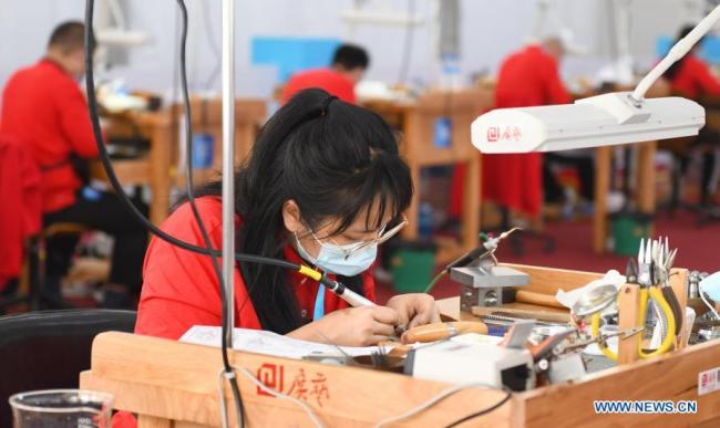 Soutěžící se účastní akce výroby šperků v druhý den první soutěže odborných dovedností Čínské lidové republiky, která se konala 11. prosince 2020 v Kantonu v jihočínské provincii Guangdong (Kuang-tung). (Xinhua / Lu Hanxin)