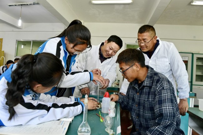 Cai Chunting (uprostřed), učitel z Xiangyangu v centrální čínské provincii Hubei, a Cering Choden (vzadu vpravo), místní učitel chemie na střední škole Shannan č. 1 v jihozápadní čínské Tibetské autonomní oblasti Xizang, 7. května, 2019. / Xinhua