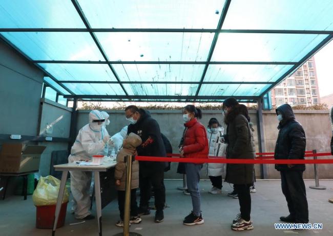 Zdravotničtí pracovníci odebírají vzorky výtěrů od obyvatelů na sídlišti ve čtvrti Qiaoxi v Shijiazhuang, hlavním městě severočínské provincie Hebei, 6. ledna 2021. Shijiazhuang začal ve středu provádět v celém městě testy nukleových kyselin. (Xinhua)