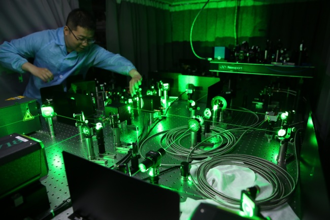Čínští výzkumníci pracují na zařízení pro ultra-podchlazení atomů v laboratoři Kvantové výpočetní techniky CAS-Alibaba v Šanghaji v Číně, dne 30. července 2015.