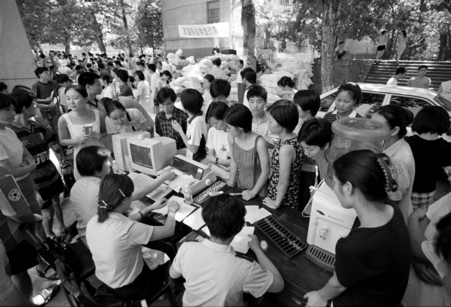 V roce 1999 zaměstnanci na nádraží Wuchang (Wu-čchang) v Hubei (Chu-pej) prodávali studentům vysokých škol letní lístky na vlak. Na konci 90. let představilo ministerstvo železnic počítačový systém, který výrazně zlepšil efektivitu prodeje jízdenek. Fotografie: Yuan Ruilung (Jüan Žuej-lung) pro deník China Daily