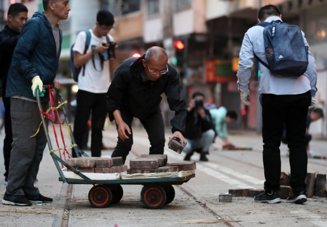 Místní obyvatelé odstraňují zátarasy na ulici v Sai Wan Ho v Hongkongu v jižní Číně, 15. listopadu 2019. (Xinhua)
