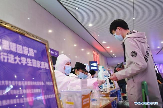 Vracející se cestující se zaregistruje na bezplatnou jízdu na nádraží Shijiazhuang (Š'-ťia-čuang) během pandemie COVID-19 v Shijiazhuangu v provincii Hebei (Che-pej) v severní Číně 18. ledna 2021. Vzhledem k tomu, že všechny ostatní služby veřejné dopravy v Shijiazhuangu byly pozastaveny z důvodu prevence a kontroly COVID-19, místní řidiči se nabídli s dobrovolnou pomocí. 800členný tým dobrovolných řidičů, který vede 36letý Fan Yuejia, poskytuje cestujícím, kteří přijedou do tohoto města před čínským lunárním novým rokem, bezplatné jízdy. (Xinhua / Zhu Xudong)