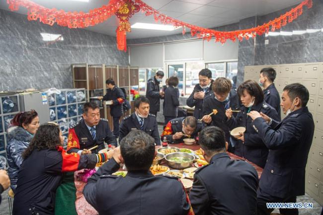 Řidiči autobusů a zaměstnanci autobusového nádraží večeří v předvečer Jarního svátku v Hangzhou (Chang-čou) ve východočínské provincii Zhejiang (Če-ťiang), 11. února 2021. Letošní Jarní svátek připadá na pátek. (Xinhua / Jiang Han)