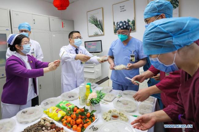 Zdravotničtí pracovníci z oddělení pohotovosti jedí v kanceláři v nemocnici Peking Union Medical College Hospital v Pekingu, hlavním městě Číny, 11. února 2021. Letošní Jarní svátek připadá na pátek. (Xinhua / Zhang Yuwei)