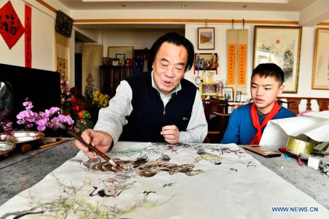 Malíř Wu Zehao (Wu Ce-chao) vytváří obraz s buvolem pro čínský lunární Nový rok ve městě Jinan (Ťi-nan) ve východočínské provincii Shandong (Šan-tung), 2. února 2021. Čínský lunární Nový rok neboli Jarní svátek oslavuje začátek nového roku podle tradičního čínského lunárního kalendáře. 12. února 2021 je prvním dnem roku buvola. (Xinhua / Guo Xulei)