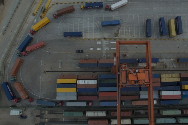 Nákladní vozy přepravující čínské zboží vykládají kontejnery, které mají být přepraveny prostřednictvím čínsko-evropské nákladní železniční dopravy na nádraží Yiwu Západ 28. prosince 2016. (Xinhua / Huang Zongzhi)