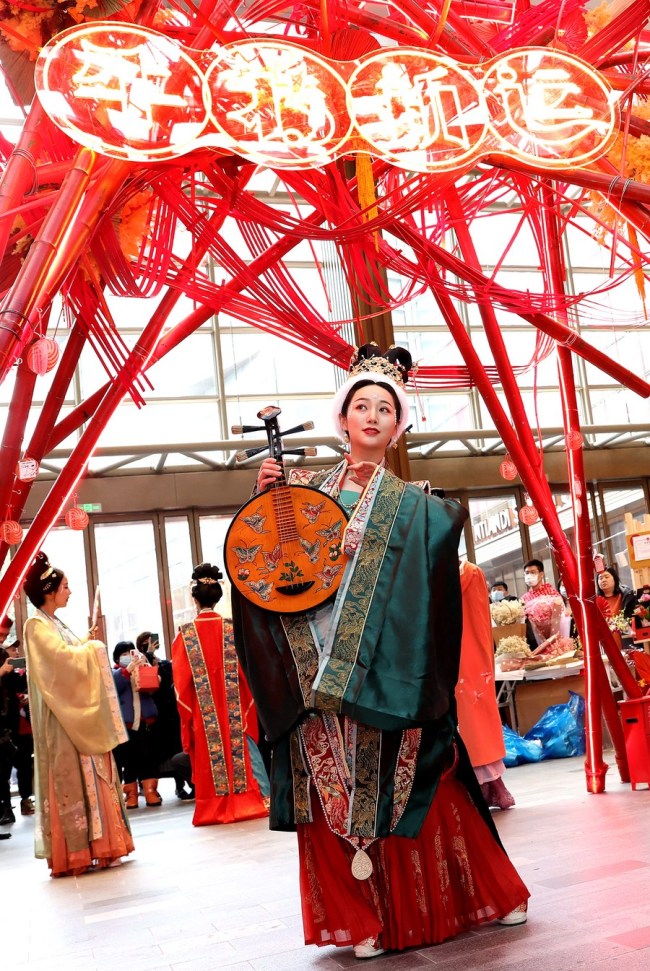 Umělec představuje tradiční oblečení v nákupním středisku ve východočínské Šanghaji, 12. února 2021. (Xinhua / Chen Fei)