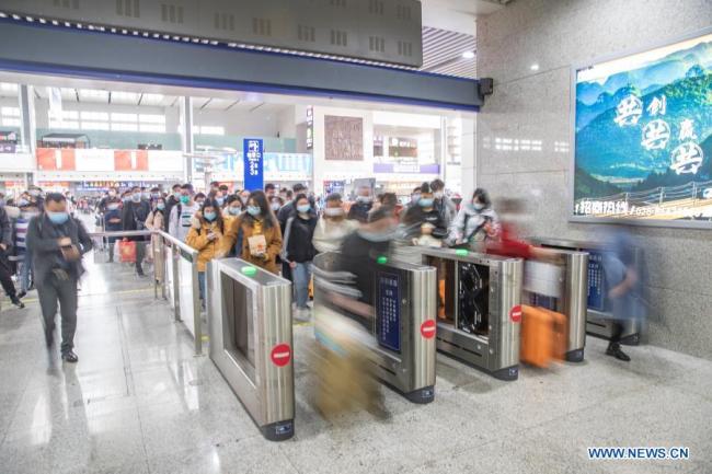 Cestující se registrují na nádraží Chongqing-sever (Čchung-čching) ve městě Chongqing v jihozápadní Číně, 17. února 2021. Ve středu je poslední den Jarních svátků. Železniční nádraží vstoupila do špičky vracejících se cestujících a železniční oddělení Chongqing podniklo opatření, aby cestující mohli cestovat snadno a bezpečně. (Xinhua / Huang Wei)
