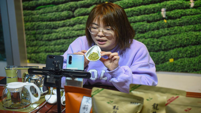 Snímek: Ye Yuzhu (Je Jü-ču) představuje čaj divákům prostřednictvím přímého přenosu na čajovém trhu v okrese Songyang (Sung-jang) ve městě Lishui (Li-šuej) ve východočínské provincii Zhejiang (Če-ťiang); 25. února 2021. (Xinhua / Jiang Han)