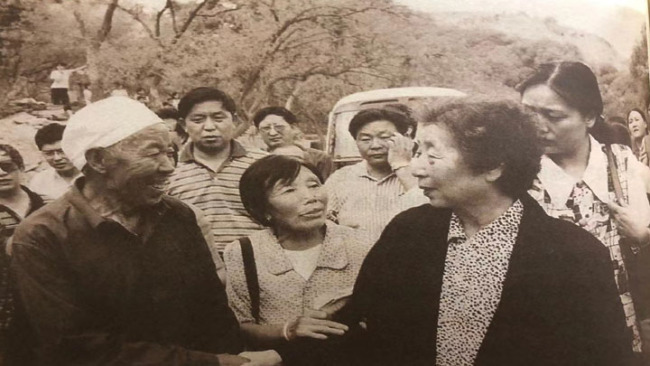 Snímek: v létě roku 2000 se paní Qi Xin vrátila do vesnice Haojia (Chao-ťia), aby navštívila místní vesničany.
