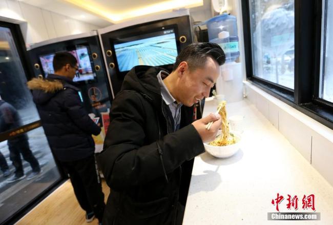 Un homme achète des nouilles dans un petit restaurant à paiement automatique situé dans la rue Qujiang de Xi’an, dans la province du Shaanxi (centre), le 4 janvier 2018. 