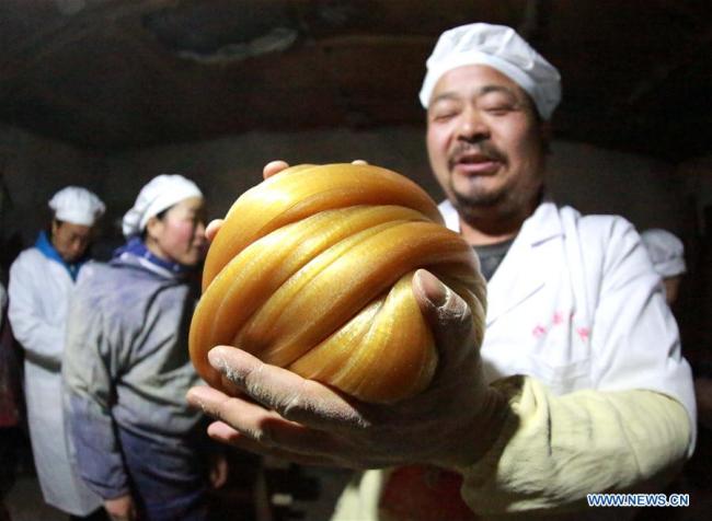  Un villageois fabrique du "sitang", une spécialité sucrée, à l'approche du Nouvel An chinois, à Diantou, village du district de Xiajiang, dans la province chinoise du Jiangxi (est), le 8 février 2018. Fabriquer du "sitang" avant la fête du Printemps est une tradition locale pour les habitants de Diantou. (Photo : Zeng Shuangquan)