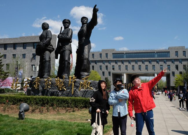 Les jeunes imitent les postures de la statue emblématique du studio cinématographique de Beijing, prédécesseur du Groupe du Film de Chine