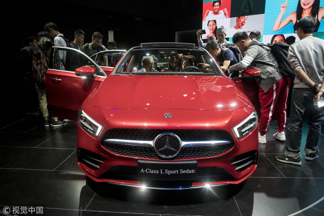 Des visiteurs observent une nouvelle berline de sport Mercedes-Benz Classe-A L lors d'une première au salon Auto China 2018, le 24 avril 2018 à Beijing.