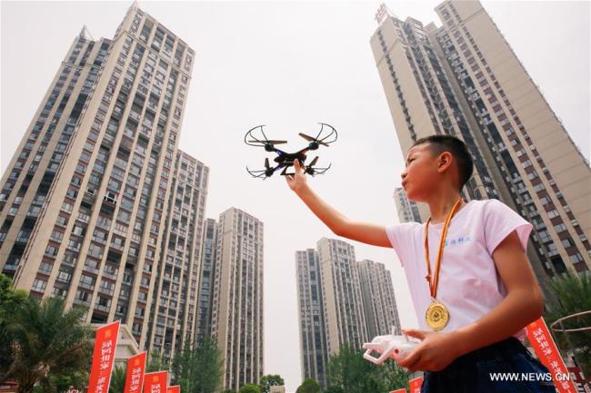 Un enfant pilote un drone lors d'un festival de robotique pour la jeunesse, dans le district de Longhui de la province chinoise du Hunan (centre), le 5 mai 2018. (Photo : Zeng Yong)