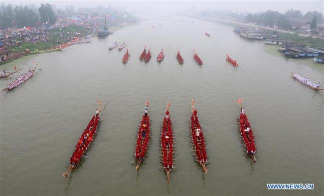 Des gens participent à un concours de bateaux-dragons sur la rivière Yuxi entre le district de Hanshan et le district de Wuwei, dans la province de l'Anhui (est de la Chine), le 3 juillet 2018. (Xinhua/Su Zishan)