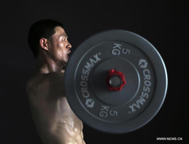 Ni Mincheng s'entraîne dans sa salle de gym à Jinhua, dans la province chinoise du Zhejiang, le 2 juillet 2018. Ni Mincheng a perdu ses bras quand il était petit. Il est ensuite devenu athlète. Maintenant il dirige sa propre salle de gym. (Photo : Ge Yuejin)