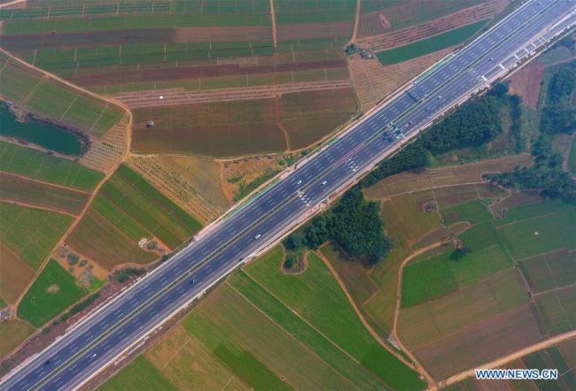 Photo aérienne prise le 10 novembre 2018 d'une autoroute reliant Liuzhou à Nanning dans la région autonome Zhuang du Guangxi, dans le sud de la Chine. Le Guangxi s'est attaché à développer un système de transport global, terrestre, aérien et maritime. Ses capacités de transport ont été considérablement améliorées. La région possède 1.751 km de ligne ferroviaire à grande vitesse et 5.000 km d'autoroutes. La capacité de traitement annuelle des ports côtiers et intérieurs a respectivement atteint 250 millions de tonnes et 110 millions de tonnes. Chaque année, environ 30 millions de voyages sont effectués par avion dans le Guangxi. (Photo : Huang Xiaobang)