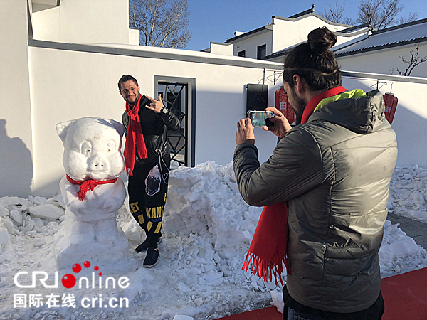 Un étudiant étranger fait une photo souvenir avec la sculpture de glace (photographe : Wang Ran)