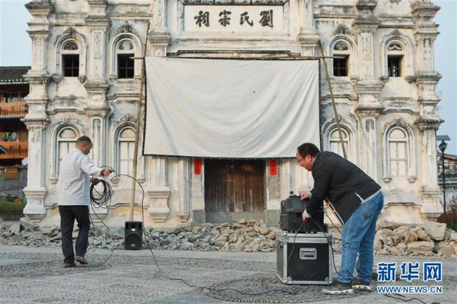 Le 19 mars, dans le village de Sanmentang, Huang Yibin est en train de transporter des équipements de projection de film.