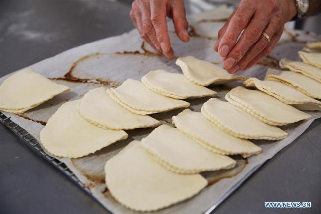 Un boulanger fabrique des pains lors de la fête du Pain à Paris, en France, le 11 mai 2019. La 24e édition de la fête du Pain est organisée à Paris du 11 au 19 mai sur la Place Louis-Lépine, près de la cathédrale Notre-Dame. (Photo : Gao Jing)<br/><br/>
