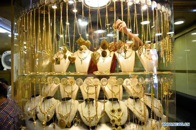 Un marchand montre des objets en or sur un marché de l'or dans la ville de Gaza, le 8 juillet 2019. (Xinhua/Str)