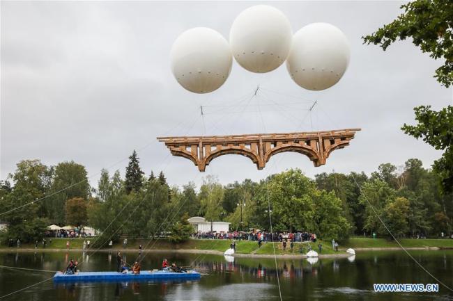 Un pont volant fait de carton et de scotch dans le parc Ostankino, à Moscou, en Russie, le 1er août 2019. Un pont volant long de 18 mètres, composé de carton et de scotch, a été assemblé et installé jeudi dans le parc Ostankino de Moscou. Le pont a été soulevé dans les airs à l'aide de trois ballons d'hélium. (Photo : Maxim Chernavsky)