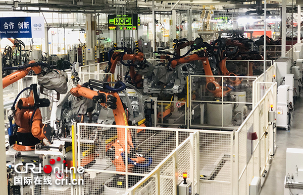 Dans l’atelier de soudage, des robots industriels travaillent en ordre