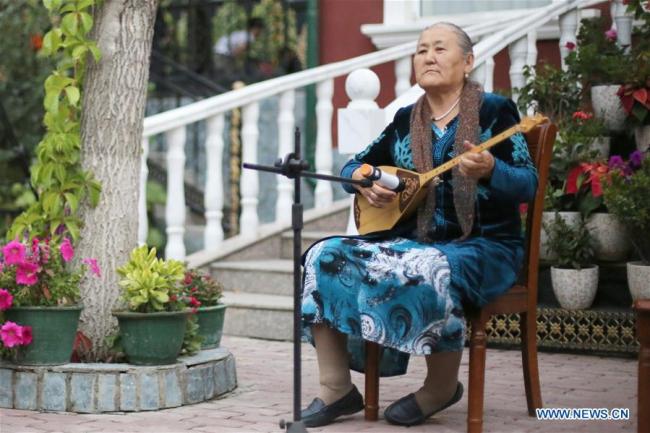 Une habitante joue d'un instrument de musique pendant une fête à Tacheng, dans la région autonome ouïgoure du Xinjiang (nord-ouest), le 4 septembre, 2019. (Photo : Cheng Li)