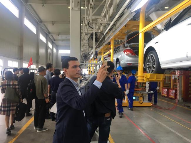 Le journaliste des Emirats Arabes Unis Zrykou Rachid filme avec son smartphone le processus de fabrication des voitures de nouvelle énergie