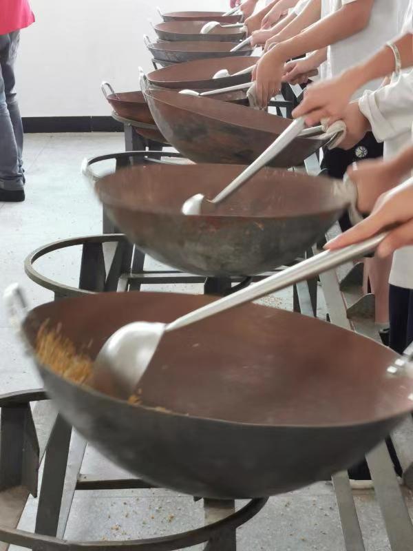Les apprentis pratiquent avec une marmite en fonte, en vue de maitriser la technique de brandiller.