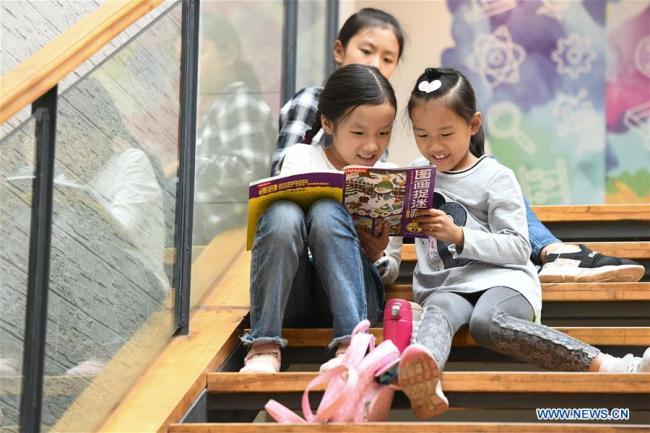 Des fillettes lisent un livre dans une librairie Xinhua pendant les vacances de la fête nationale à Hefei, capitale de la province chinoise de l'Anhui (est), le 6 octobre 2019. (Photo : Zhang Duan)