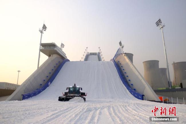 Le 8 décembre, de la neige artificielle a commencé à être dispersée dans le parc Shougang de Beijing, qui accueillera prochainement une compétition mondiale de ski et de snowboard.