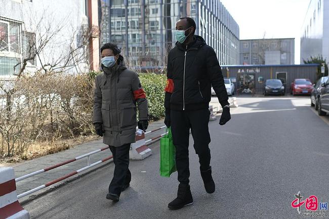 Un jeune Africain sert en tant que bénévole dans un quartier à Beijing pour lutter contre l’épidémie