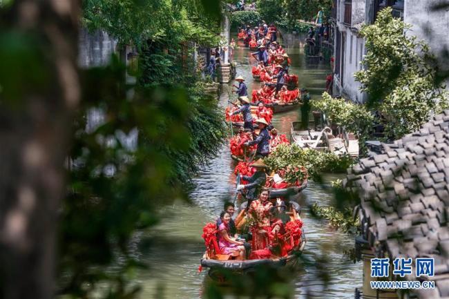 Le 20 mai, un mariage collectif traditionnel a été organisé dans le vieux village de Zhouzhuang, réputé comme « la petite Venise de Chine », dans la province du Jiangsu (est). Un total de 52 couples se sont dit « oui » avec style à cette occasion et ont pris des bateaux pour faire une visite du village.