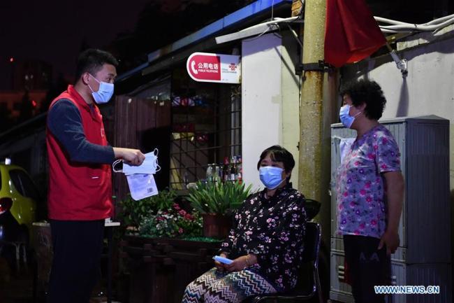 Yang Longming distribue les masques de protection grand public  aux habitants.
